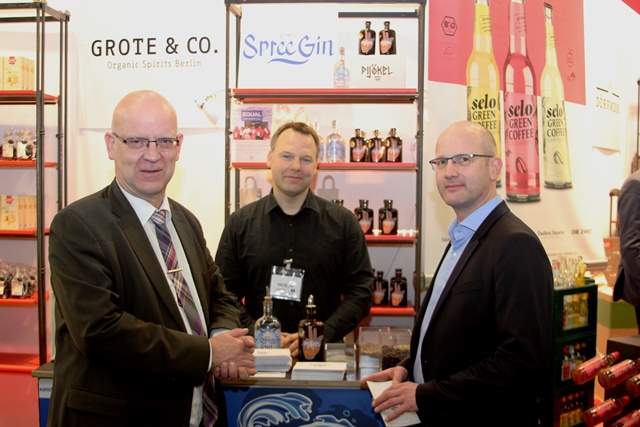 Landrat Stephan Loge (l.) informiert sich am Berlin-Brandenburger Gemeinschaftsstand auf der Messe BIOFACH 2019. Hier im Gespräch mit Sascha Philipp, (r.) Geschäftsführer Landgut Pretschen, und Henning Birkenhake, Inhaber von Spree-Gin Berlin. (Foto: Landkreis Dahme-Spreewald)