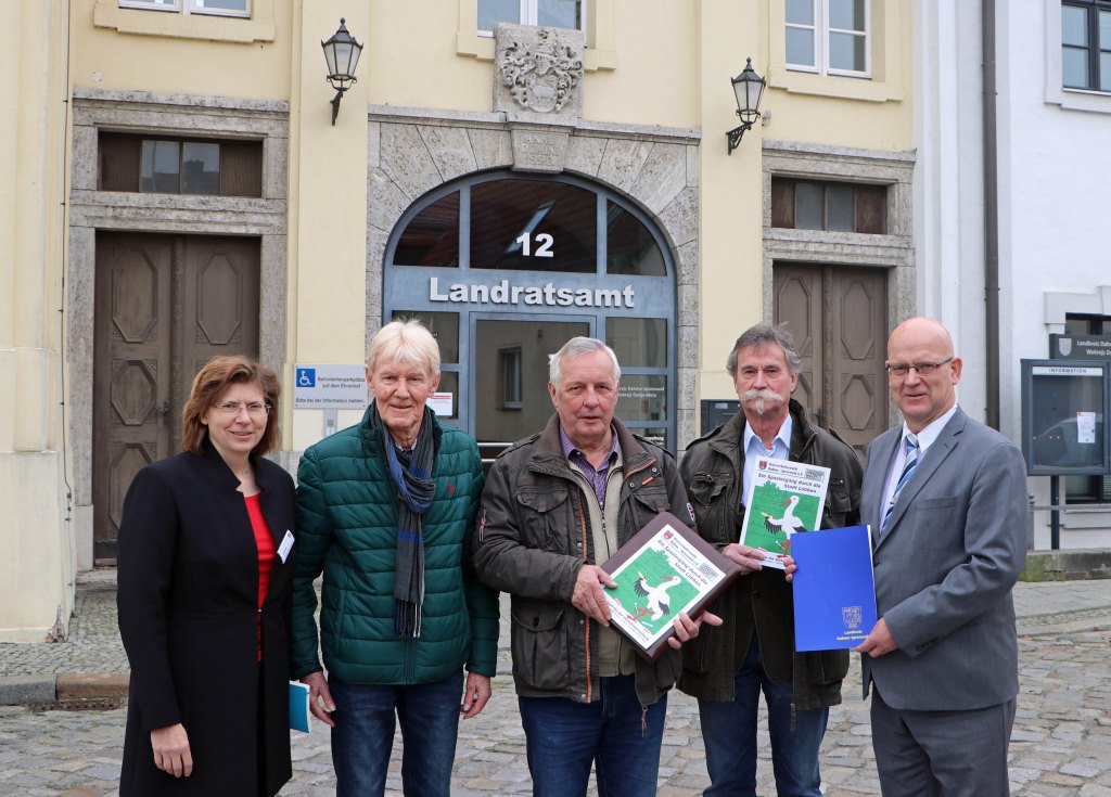 Landrat Stephan Loge (r.) und Verkehrsdezernentin Heike Zettwitz (l.) übergeben den Mitgliedern der Kreisverkehrswacht Martin Wille, Johannes Haarich und Uwe Schulze den Zuwendungsbescheid für das neue Malbuch-Projekt (Foto: Dahme-Spreewald)