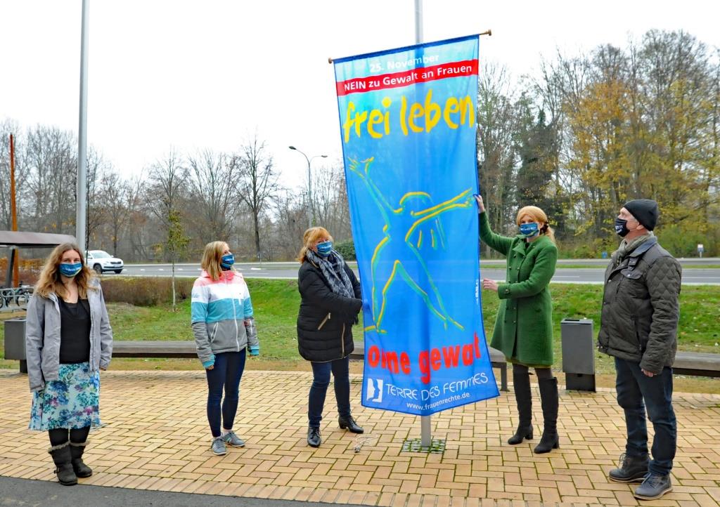 Dahme-Spreewalds Vize-Landrätin Susanne Rieckhof (2.v.r.) und Gleichstellungsbeauftragte Elke Voigt (M.) hissen gemeinsam mit dem Personalratsvorsitzenden Ralf Kunze (r.) sowie Mitarbeiterinnen des Bereichs Gleichstellung die Fahne „frei leben − ohne Gewalt“ am Verwaltungsgebäude des Landkreises in Königs Wusterhausen. (Foto: Gerlinde Irmscher / LDS)