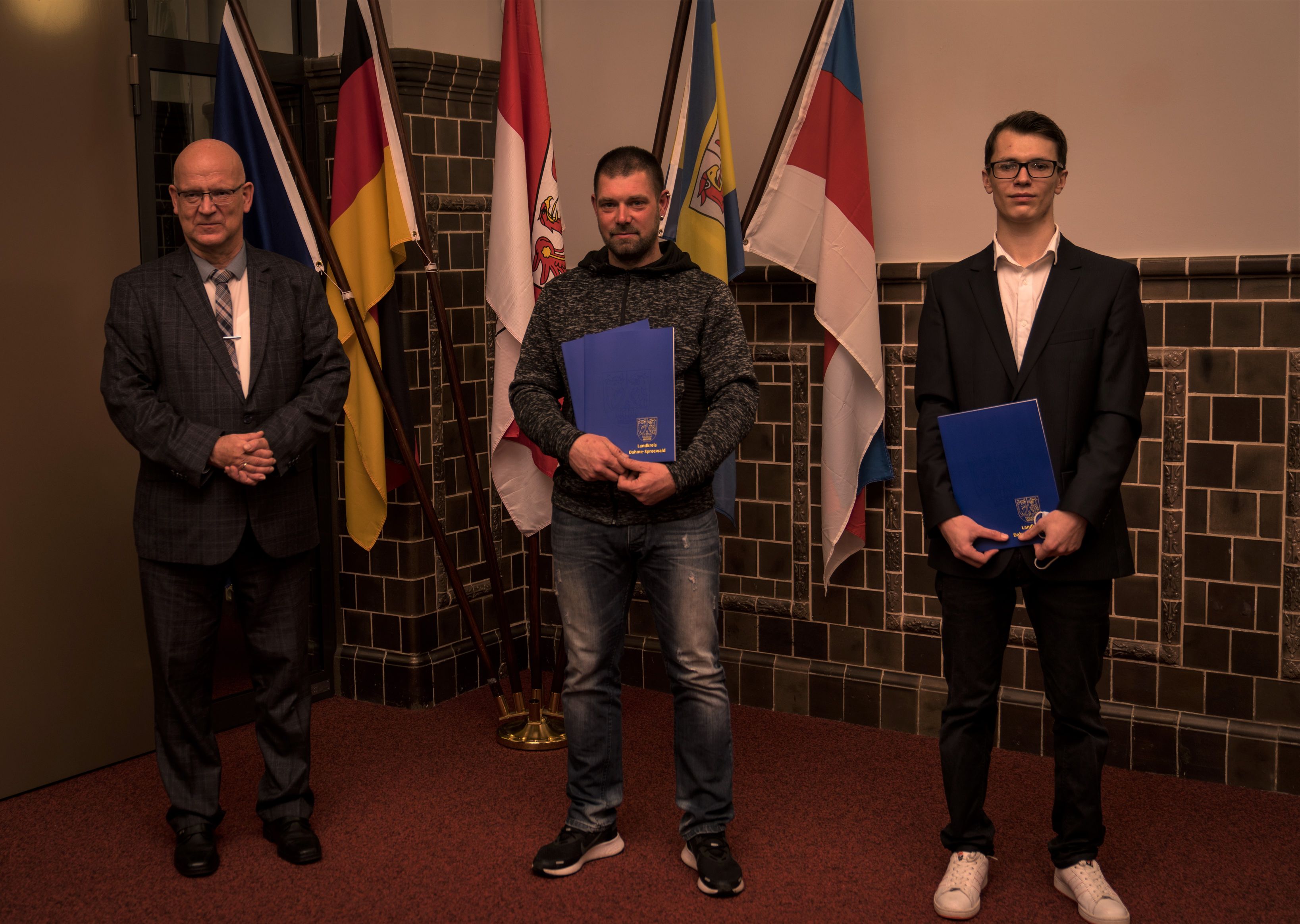 Zwei der Preisträger haben ihre Ehrung persönlich entgegengenommen: Mike Albrecht (Mitte) und Vjatscheslav Forot (rechts). Landrat Stephan Loge (links) hat die Ehrung vorgenommen. (Foto: LDS/pixlparty)