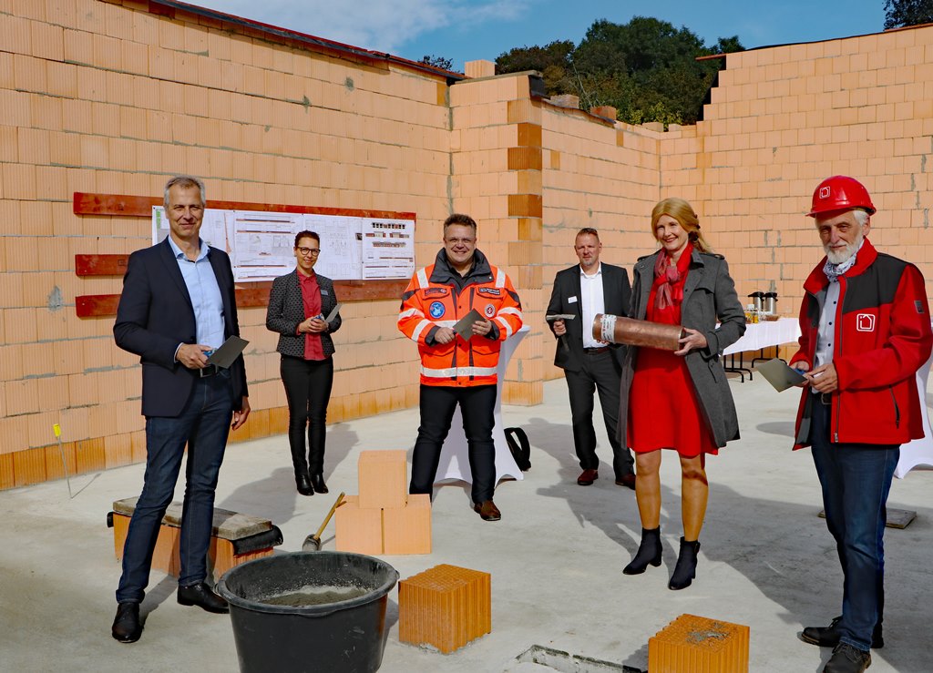 Vizelandrätin Susanne Rieckhof (2.v.r.) hat zusammen mit Bürgermeister Markus Mücke, DRK-Abteilungsleiterin Anja Thoß, Johanniter-Regionalvorstand Andreas Berger-Winkler, Ordnungsdezernent Stefan Klein und Planungsingenieur Matthias Bärmann (v.l.n.r) die Zeitkapsel im Grundstein einzementiert. (Foto: Landkreis Dahme-Spreewald)