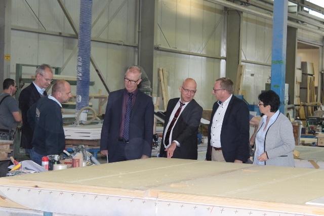 Jens-Herrmann Kleine (Amtsdirektor des Amtes Unterspreewald), Tomasz Krzeminski (Produktionsleiter der der Architektur in Holz GmbH), Gerhard Janßen (Geschäftsführer der Wirtschaftsförderungsgesellschaft Dahme-Spreewald mbH), Stephan Loge (Landrat), Robert Knittel (Geschäftsführer der Kampa Beteiligungs GmbH & Co. KG), Irene Hübner (Geschäftsführerin der Architektur in Holz GmbH) Foto: WFG