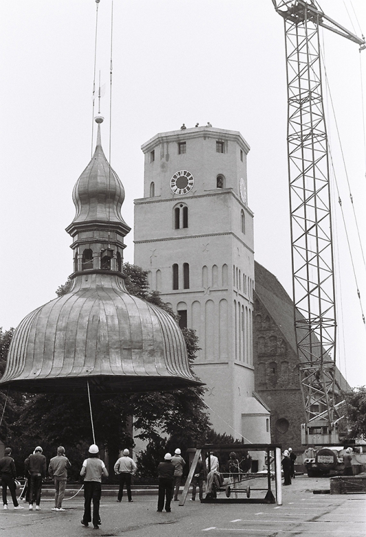 Zu sehen ist das Aufsetzen der neuen Kirchturmhaube in Lübben, 1988.