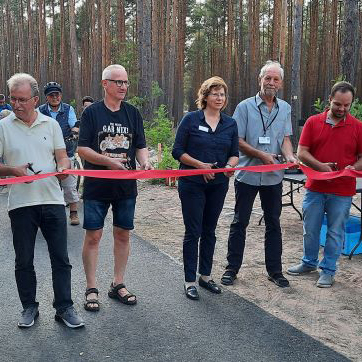 Das rote Band wird bei der Eröffnung des neuen Radweges zwischen Prieros und Kolberg durchgeschnitten.