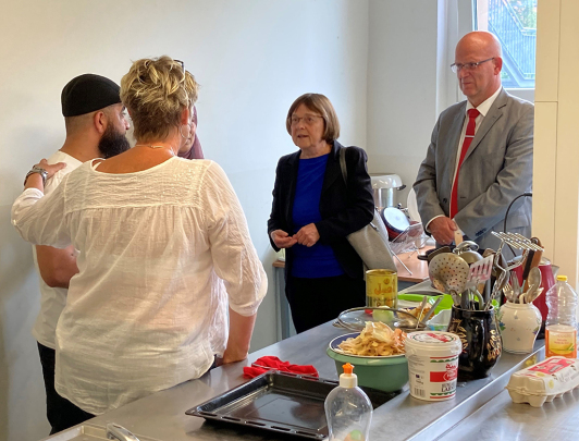 Während der Integrationstour am 28. Juli 2023 in Luckau, Landesministerin Nonnemacher und Landrat Loge im Gespräch in der Gemeinschaftsküche GU Luckau.