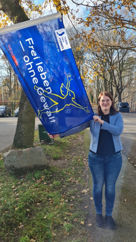 Gleichstellungsbeauftragte der Gemeinde Heideblick Sarah Jakobza hisst die Flagge an der Gemeindeverwaltung.