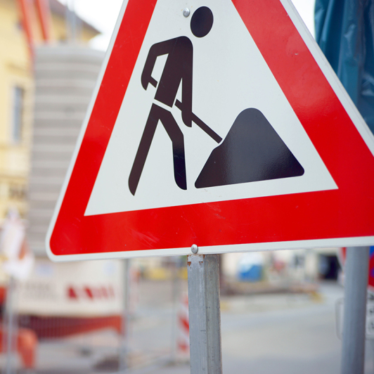 Zu sehen ist "Achtung Baustelle" auf einem Verkehrsschild.