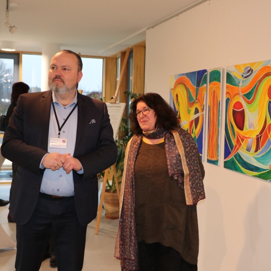 Kulturdezernent Stefan Wichary und Künstlerin Silvia Reiner schauen sich die Bilder an