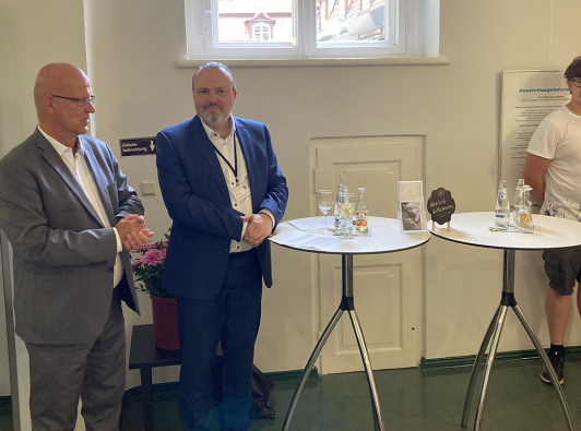 Sie sehen Landrat Stephan Loge und den Kulturdezernenten Stefan Wichary bei der Eröffnung der Austellung "14x Kunst im Landkreis".