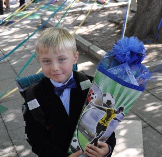 eingeschulter Junge mit Zuckertüte