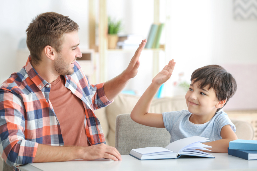 Ein junger Mann und sein kleiner Sohn lesen zu Hause ein Buch. © Fotolia/Africa Studio
