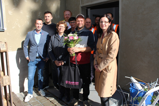 Nahmen den ersten Hausanschluss im Rahmen des geförderten Glasfaserausbaus im LDS gemeinsam in Betrieb (v.l.n.r): Vordere Reihe: Frank Schulakowski (Ausbaukoordinator Breitband Brandenburg, Deutsche Telekom Technik GmbH), Heike Zettwitz (Erste Beigeordnete und Dezernentin für Verkehr, Bauen, Umwelt und Wirtschaft des Landkreises Dahme-Spreewald), Marion Schirmer (Geschäftsführerin, Wirtschaftsförderungsgesellschaft Dahme-Spreewald mbH), Herr Greth, Diana Lemke (Gebietsmanagerin Brandenburg, Telekom Deutschland GmbH) // Hintere Reihe: Anton Scheumann (Projektmanager, Deutsche Telekom), Herr Lale (Bauleiter, O.S.T. Straßen- und Tiefbau GmbH), Herr Gürsel (Kolonnenführer, O.S.T. Straßen- und Tiefbau GmbH), Monteure der O.S.T. Straßen- und Tiefbau GmbH Nahmen den ersten Hausanschluss im Rahmen des geförderten Glasfaserausbaus im LDS gemeinsam in Betrieb (v.l.n.r): Vordere Reihe: Frank Schulakowski (Ausbaukoordinator Breitband Brandenburg, Deutsche Telekom Technik GmbH), Heike Zettwitz (Erste Beigeordnete und Dezernentin für Verkehr, Bauen, Umwelt und Wirtschaft des Landkreises Dahme-Spreewald), Marion Schirmer (Geschäftsführerin, Wirtschaftsförderungsgesellschaft Dahme-Spreewald mbH), Herr Greth, Diana Lemke (Gebietsmanagerin Brandenburg, Telekom Deutschland GmbH) // Hintere Reihe: Anton Scheumann (Projektmanager, Deutsche Telekom), Herr Lale (Bauleiter, O.S.T. Straßen- und Tiefbau GmbH), Herr Gürsel (Kolonnenführer, O.S.T. Straßen- und Tiefbau GmbH), Monteure der O.S.T. Straßen- und Tiefbau GmbH