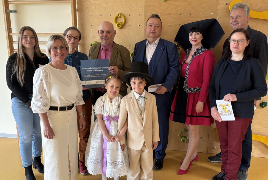 Gruppe Erwachsener und zwei Kinder schauen in die Kamera