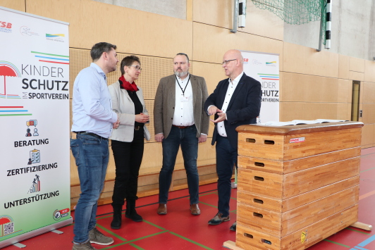 Sportjugendkoordinator des Kreissportbundes Michael Werner, Vorsitzende des Kreissportbundes Beate Burgschweiger, Sport- und Jugenddezernenten des Landkreises Stefan Wichary im Gespräch mit Landrat Stephan Loge während der Unterzeichnung der Richtlinie "Kinderschutz im Sportverein"