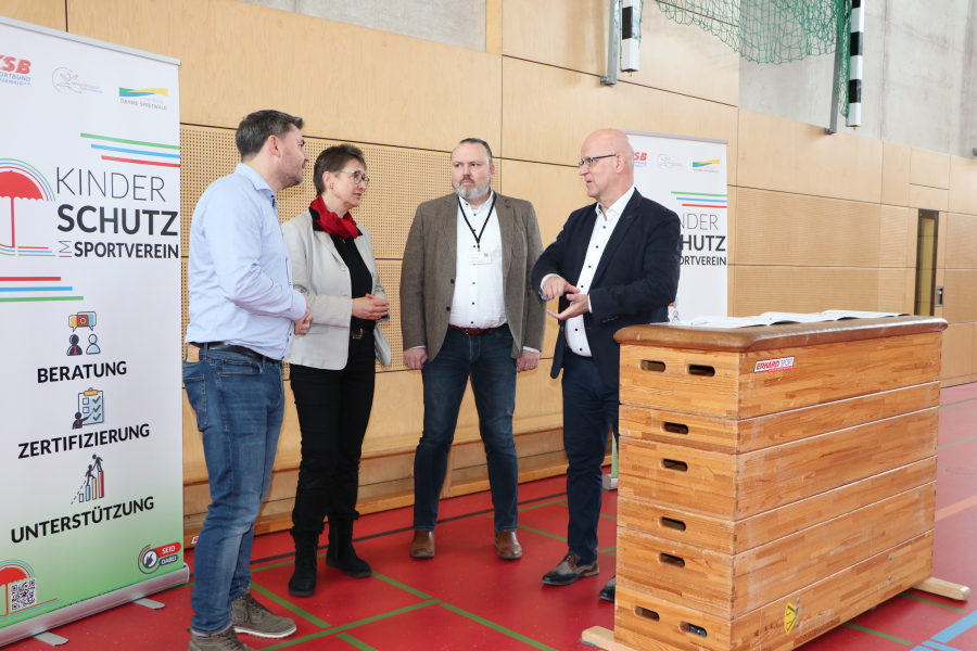 Sportjugendkoordinator des Kreissportbundes Michael Werner, Vorsitzende des Kreissportbundes Beate Burgschweiger, Sport- und Jugenddezernenten des Landkreises Stefan Wichary im Gespräch mit Landrat Stephan Loge während der Unterzeichnung der Richtlinie "Kinderschutz im Sportverein"