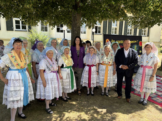 Zu sehen ist der Spreewaldfrauenchor aus Lübben mit Sozialministerin Britta Müller sowie Landrat Sven Herzberger.