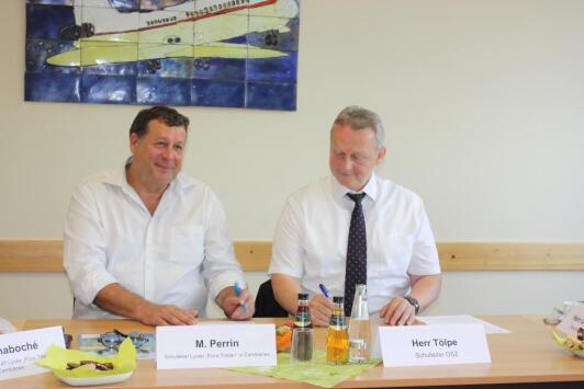 Herr Perrin und Herr Tölpe unterzeichnen den Kooperationsvertrag