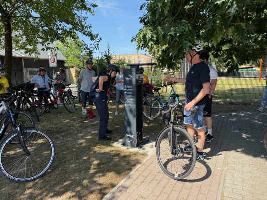 Fahrradfahrer schauen sich eine Fahrradreparaturstation an 