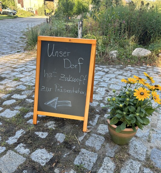 Tafel mit Aufschrift Unser Dorf hat Zukunft