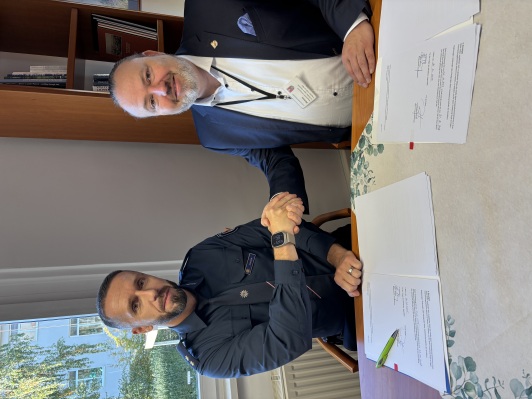 Zwei Männer schauen in die Kamera. Einer trägt eine Polizeiuniform.