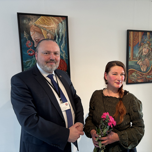 Ein Mann und eine Frau stehen vor Gemälden