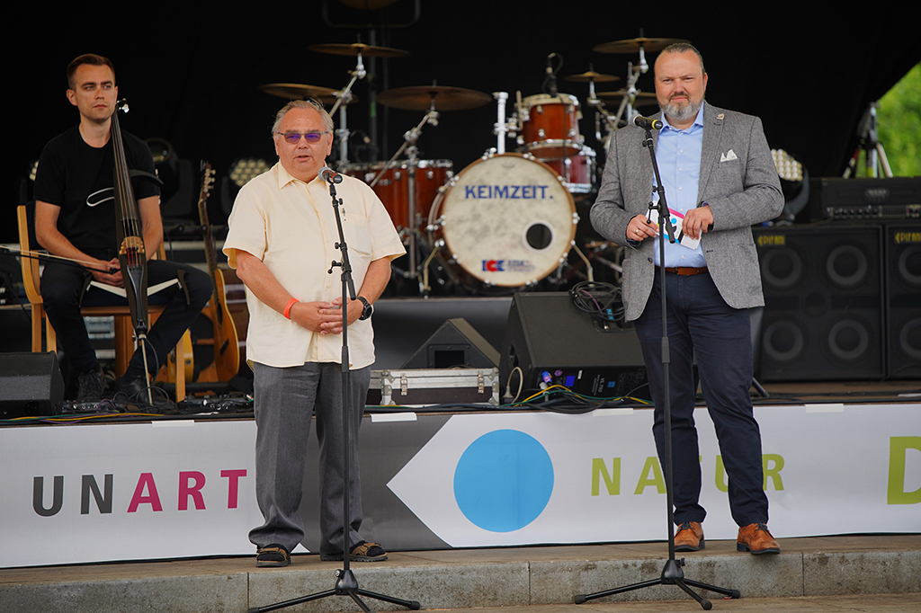 v.l.n.r.: Cellist Loop Trigger, Norbert Schmidt als Vorstandsvorsitzender des Fördervereins und Kulturdezernent Stefan Wichary begrüßen zur Preview in Goyatz auf der Seebühne (Fotos: Stefan Otto)
